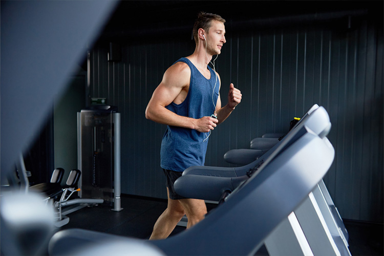 Man is training on treadmill in the gym