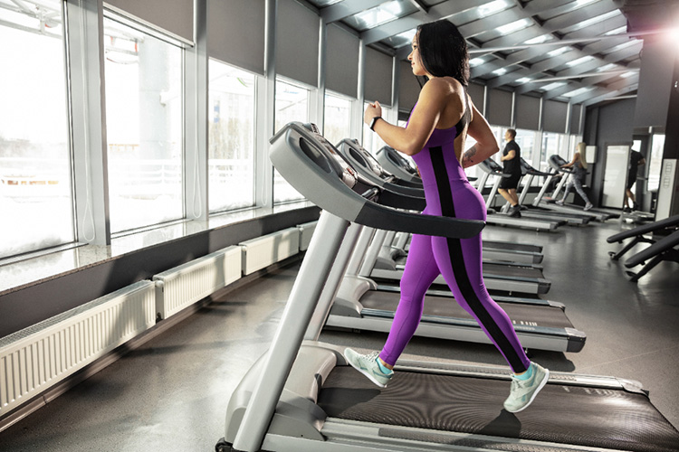 Young muscular woman practicing in gym with cardio